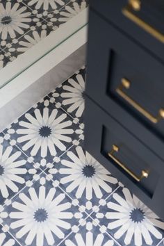 two drawers are next to each other on a tiled floor with white and black designs