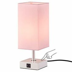 a pink lamp is plugged in to a white box with a black cord on it