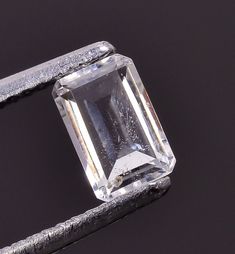 an emerald cut diamond sitting on top of a piece of metal