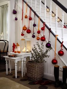 christmas decorations hanging from the banisters in a home's entryway, decorated with red and gold baubs