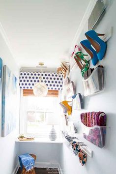 there are many shoes hanging on the wall in this small room, and one is blue with white polka dots