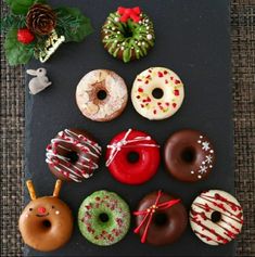 there are many different donuts on the black board with red, white and green frosting