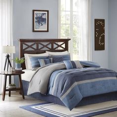 a bed with blue and white comforters in a room