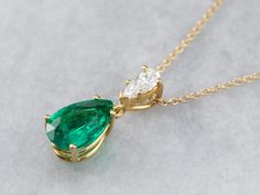 This lovely necklace was crafted in our shop, using both vintage and modern pieces. The center gem is a deep, gorgeous green emerald from our collection! We've used a brilliant diamond as an accent, and set them both in a simple yellow gold pendant with clean, simple lines. Set perfectly on a yellow gold rolo 16-inch chain, making this stunning piece ready to wear or gift! Metal: 18K Yellow Gold Gem: Emerald 2.57 Carats Gem Measurements: 12.0 x 8.2 mm, Pear Cut Accents: Diamond .42 Carats, F in Elegant Yellow Gold Emerald Necklace With Diamond Accents, Elegant Brilliant Cut Emerald Necklace In Yellow Gold, Green Diamond Necklace In Fine Jewelry Style, Timeless Green Necklace For Formal Occasions, Elegant Emerald Diamond Necklace With Brilliant Cut, Timeless Green Emerald Necklace As A Gift, Classic Green Necklaces With Diamond Accents, Exquisite Emerald Necklace With Prong Setting, Emerald Necklace With Diamond Cut In Fine Jewelry Style