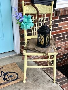 a cat sitting on a chair next to a blue door with purple flowers in it