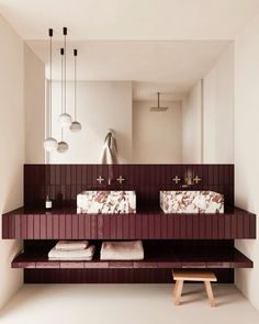 a bathroom with two sinks, mirrors and lights above it's counter top area