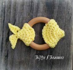 a crocheted ring with two little yellow fish on it, sitting on a wooden surface