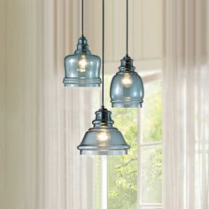 three light fixtures hanging from a ceiling in front of a window with the words the home depot