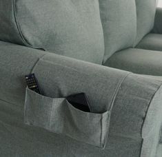 a remote control sticking out of the pocket of a couch