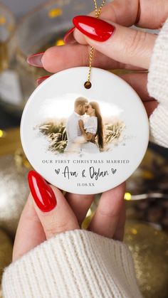 a woman's hand holding a christmas ornament with a photo on it