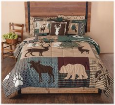 a bed with a bear and moose quilt on it's coverlet next to a chair