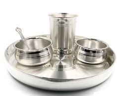 a silver plate with cups and saucers on it