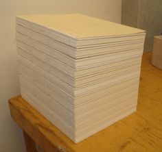 a stack of white paper sitting on top of a wooden table