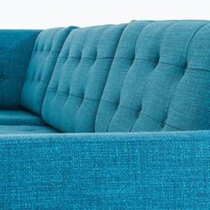 a blue couch sitting on top of a wooden floor