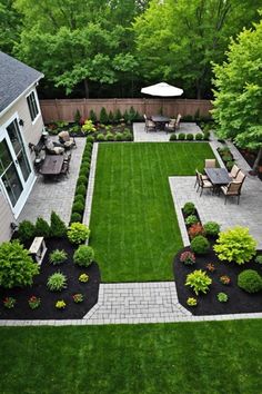 an aerial view of a backyard with lawn and patio furniture, trees, shrubs, and grass