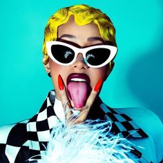 a woman with yellow hair and sunglasses making a funny face while holding her tongue out