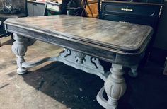 an old table is being worked on in a shop with other antique furniture and antiques