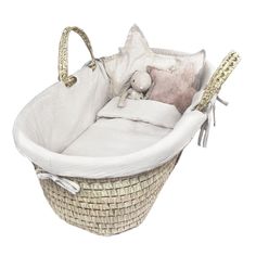 a white basket with a stuffed animal in it and some pillows on the bottom half