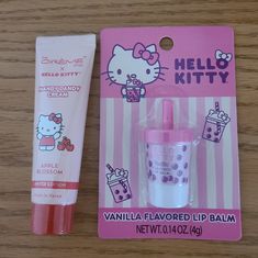 hello kitty lip balm next to an empty bottle on a wooden table with a pink package