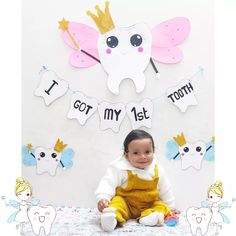 a baby sitting on a bed in front of a wall with toothpaste cutouts