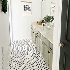 a white bathroom with black and white floor tiles