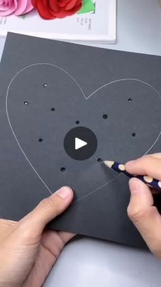 someone is making a heart out of paper and glues it to the side of a card