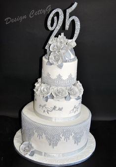 a white wedding cake with silver flowers and the number twenty five