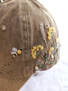 a brown hat with yellow flowers and bees on it