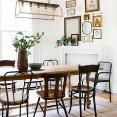 a dining room table with chairs and pictures on the wall