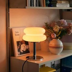 a lamp is sitting on top of a shelf next to some books and other items