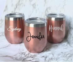 three wine glasses with names on them sitting on a marble surface