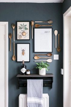 a blue wall with spoons, utensils and pictures hanging on the wall