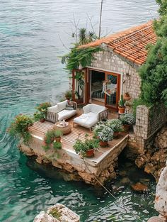 a house built into the side of a cliff with plants growing on it's roof