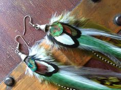 "Long and beautiful feather earrings with a boho hippie feel. These have a lovely combination of greens mixed with white, grizzly, and grey. Finished with a bead cap, and ear hooks with stoppers so you so not loose your feathers. Light as a feather, layered, 8-9\" long You will look fab and will be the envy of the room! If you prefer clip on's or hooks leave a note at check out...no extra charge. shipped in a gift box for safe travel and storage. Gift wrap is free. If you would like this please Green Bohemian Feather Earrings, Bohemian Green Feather Earrings, Green Bohemian Earrings With Feathers, Purple Feather, Light As A Feather, Boho Green, Cluster Earrings, Ear Hook, Feather Earrings