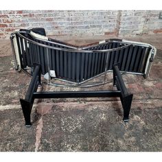 an old fashioned black and white radiator sitting on the ground in front of a brick wall