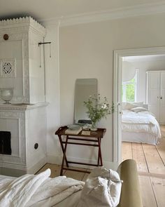 a bedroom with a fireplace, mirror and bed