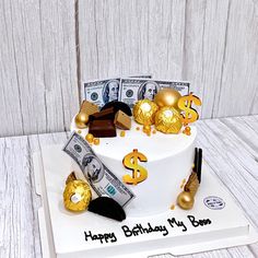 a birthday cake with money and gold decorations