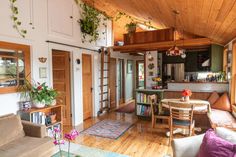 a living room filled with furniture next to a kitchen and dining room table on top of a hard wood floor