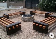 an outdoor fire pit surrounded by wooden benches