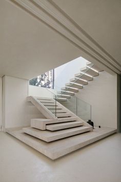 the stairs are made of concrete and have glass railings