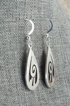 These sterling silver earrings are made by Hopi silversmith Timothy Mowa. The backs are signed and stamped sterling.Length: 1 5/8"Width: 1/2"Free shipping on all orders! We ship with USPS and always include tracking. All orders ship within a day of payment.Returns are accepted up to 30 days after you receive your order. Just send us a message. Our shop offers cash back or store credit. The item must be returned in new condition. Hallmarked Sterling Silver Teardrop Jewelry, Engraved Sterling Silver Drop Earrings, Engraved Teardrop Sterling Silver Earrings, Silver Symbolic Engraved Earrings, Symbolic Sterling Silver Pierced Earrings, Silver Engraved Symbolic Earrings, Symbolic Engraved Silver Earrings, Silver Engraved Teardrop Earrings, Silver Teardrop 925 Stamped Jewelry