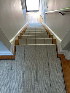 an empty staircase with carpeted steps leading up to the window