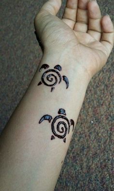 a woman's arm with two tattoos on it, one turtle and the other bird