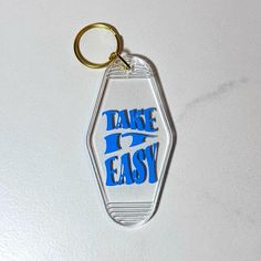 a plastic keychain with the words take it easy on it