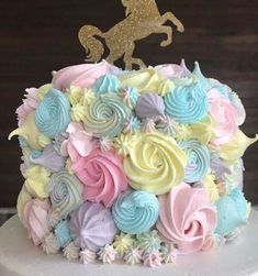 there is a cake decorated with pastel colors and a gold horse on the top