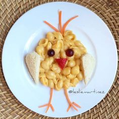 a white plate topped with macaroni and cheese shaped like a chicken's face