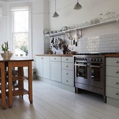 a kitchen with white walls and wooden floors