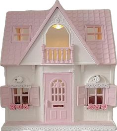 a pink and white doll house with windows