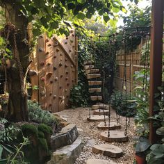 an outdoor climbing wall in the middle of a garden with steps leading up to it