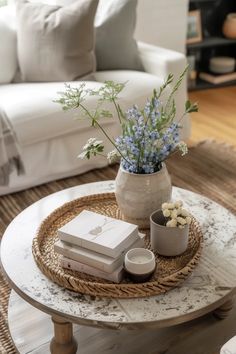 a coffee table with flowers and books on it